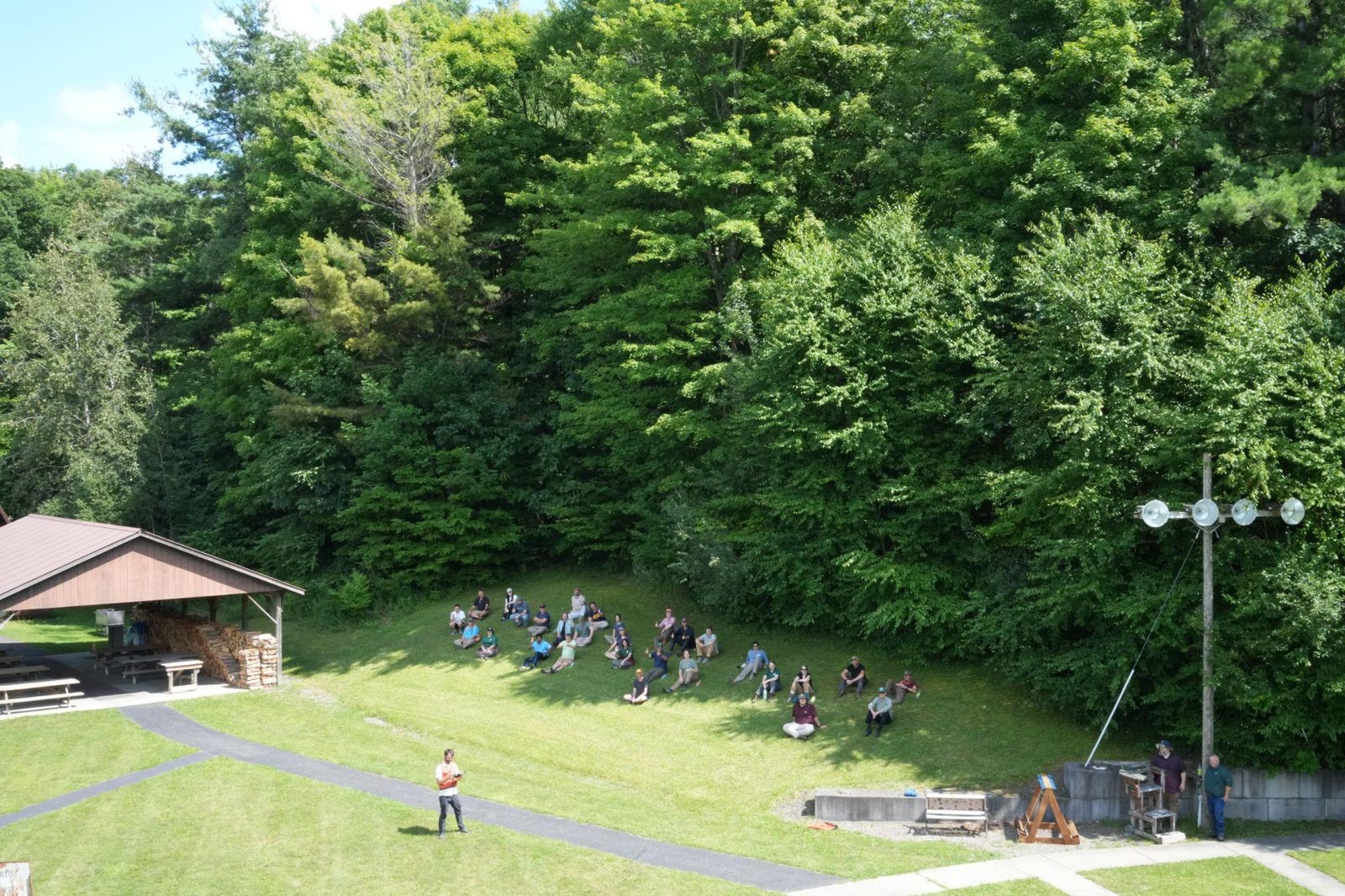 Workshop participants seated on a forest clearing for an outdoor session